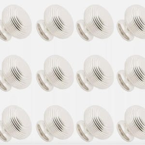 May include: A collection of twelve silver cabinet knobs. Each knob features a rounded, ribbed design and a small, circular base. The knobs are arranged in three rows of four against a plain white backdrop.