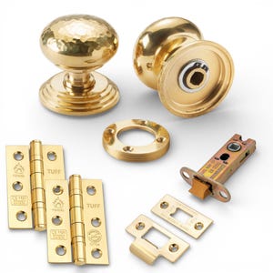 May include: A selection of brass door hardware, featuring two doorknobs, hinges, a strike plate, and a latch. The doorknobs have a hammered finish. The hinges and strike plate are stamped with the word "TUFF".
