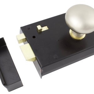 May include: A black door lock with a silver knob and brass components. The lock includes a separate black strike plate. The knob is round and the lock is rectangular.