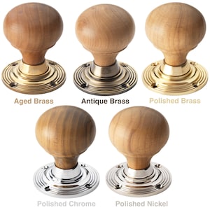 May include: A selection of wooden door knobs with different metal finishes. The knobs are spherical and made of light-colored wood. The metal bases are labelled "Aged Brass", "Antique Brass", "Polished Brass", "Polished Chrome", and "Polished Nickel".