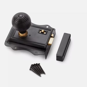 May include: Black door latch with a round, grooved knob and brass accents. Includes a matching strike plate and screws. The hardware is designed for a door and is made of metal.