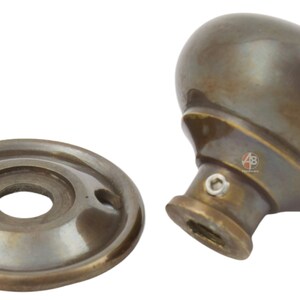 Peut inclure: Bouton de porte et plaque arri&egrave;re en bronze antique. Le bouton est de forme ovale et poss&egrave;de une courte tige. La plaque arri&egrave;re est ronde avec deux trous de vis. La quincaillerie a une esth&eacute;tique vintage.