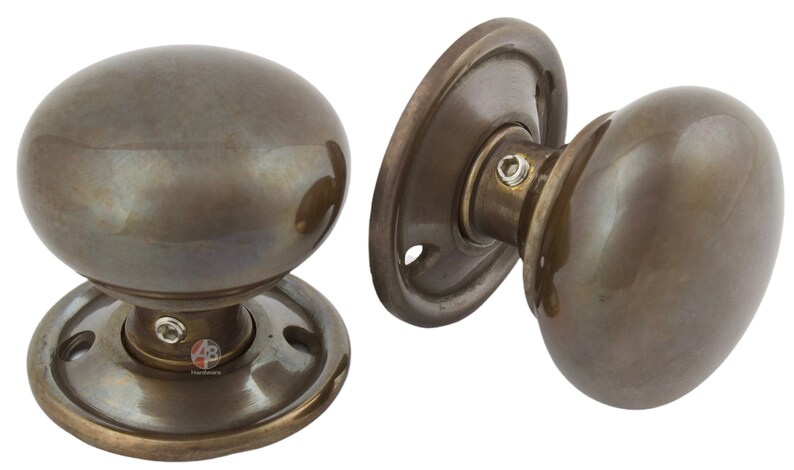 Peut inclure: Deux poign&eacute;es de porte de style antique avec une finition bronze. Chaque bouton a une forme ovale et est mont&eacute; sur une plaque arri&egrave;re ronde. La quincaillerie est en m&eacute;tal et a une esth&eacute;tique vintage.