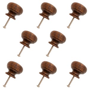 May include: Nine dark brown wooden cabinet knobs. Each knob features a grooved, rounded top and a metal screw. The knobs are presented against a white backdrop.