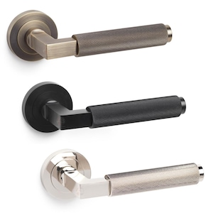 May include: Three door handles in bronze, black, and silver. Each handle features a textured grip and a square neck connecting to a round base. The bronze handle is at the top, the black in the middle, and the silver at the bottom.