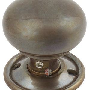 Peut inclure: Un bouton de porte en bronze avec une poign&eacute;e sph&eacute;rique. Le bouton est mont&eacute; sur une base circulaire avec des trous de vis. La quincaillerie a un aspect vieilli et antique.