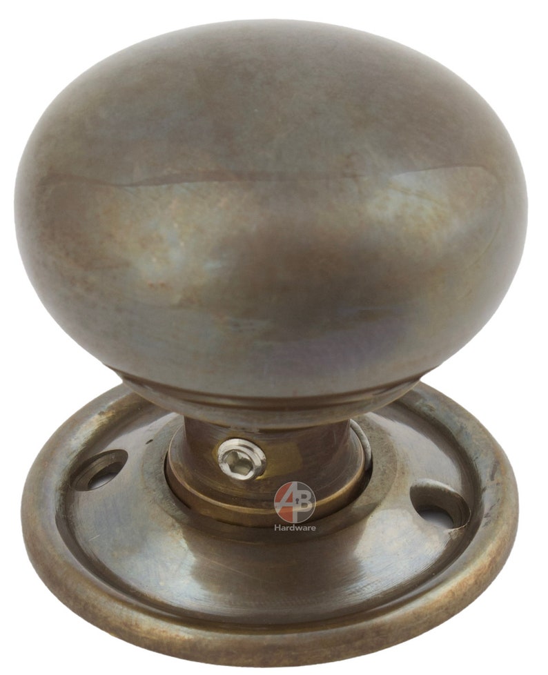 Peut inclure: Un bouton de porte en bronze avec une poign&eacute;e sph&eacute;rique. Le bouton est mont&eacute; sur une base circulaire avec des trous de vis. La quincaillerie a un aspect vieilli et antique.