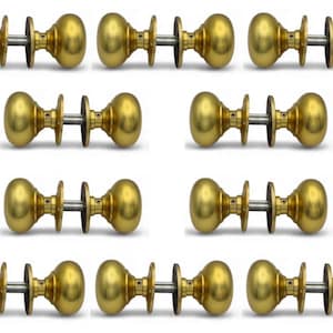 May include: Ten brass door knobs are displayed, each with a rounded design and a polished finish. The knobs are arranged in rows and columns against a white backdrop, highlighting their design and hardware details.