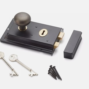 May include: A black door latch with a brass keyhole and a dark metal knob. Two silver keys and a set of black screws are included. The latch is a traditional design.