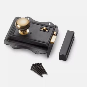 May include: A black door latch with a gold-coloured knob and accents. The latch includes a strike plate and a set of black screws. The hardware is designed for door security and home improvement projects.