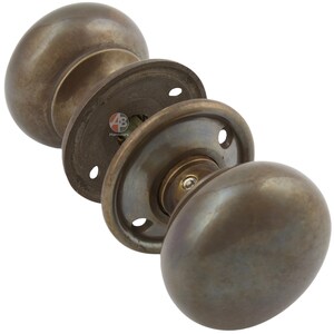 Peut inclure: Ensemble de poign&eacute;es de porte en bronze antique avec un design classique et arrondi. L'ensemble comprend deux boutons, une tige et des plaques de montage. La quincaillerie a une finition patin&eacute;e, sugg&eacute;rant un attrait vintage ou rustique.