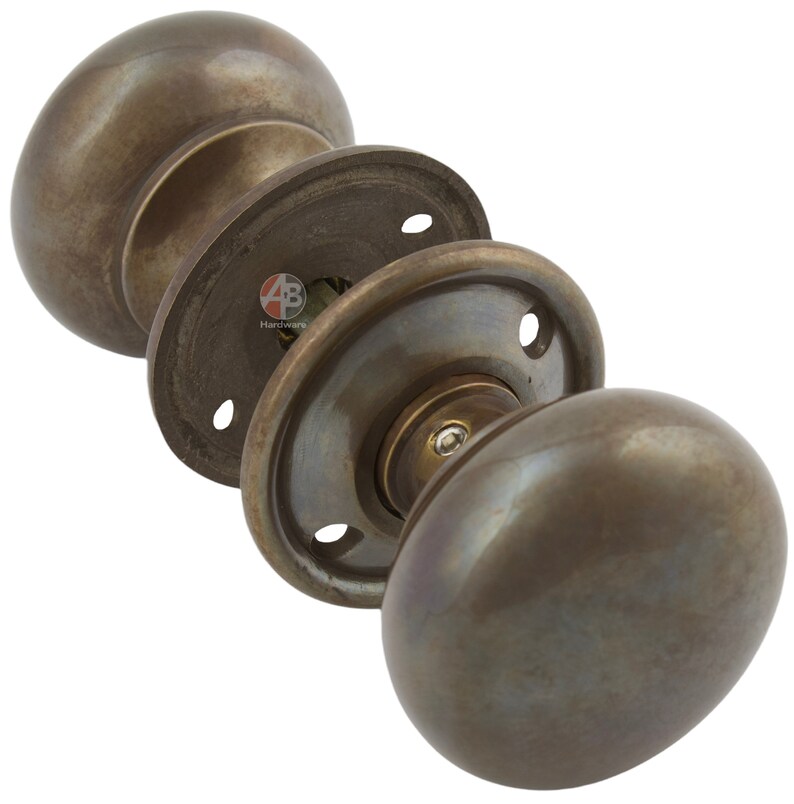 Peut inclure: Ensemble de poign&eacute;es de porte en bronze antique avec un design classique et arrondi. L'ensemble comprend deux boutons, une tige et des plaques de montage. La quincaillerie a une finition patin&eacute;e, sugg&eacute;rant un attrait vintage ou rustique.