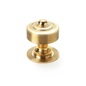May include: A gold-coloured cabinet knob with a round, ribbed design. The knob has a small, rounded top and a circular base with concentric grooves. The hardware is made of metal and is suitable for furniture or cabinetry.