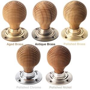 May include: Five wooden door knobs with different metal base finishes are displayed. Each knob features a grooved, spherical design. Finishes include aged brass, antique brass, polished brass, polished chrome, and polished nickel. Text labels identify each finish.