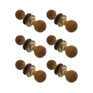 May include: Six wooden door knobs with a ribbed, spherical design. Each knob has a brass-coloured base and a dark brown mounting plate. The knobs are arranged against a white background.