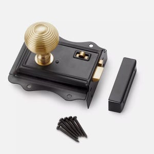 May include: A black door latch with a brass knob and accents. The latch includes a strike plate and a set of black screws. This hardware is designed for doors and cabinets.