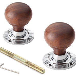 May include: Two door knobs with a dark brown, spherical wooden top and a polished chrome base. Includes a threaded rod and a hex key. The base has a ridged design. The knobs are designed for doors.