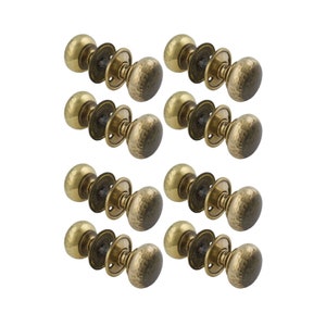 May include: Ten brass door knobs with a hammered texture are displayed. Each knob has a round, slightly flattened shape and is attached to a circular backplate. The knobs are arranged in a grid pattern against a white background.