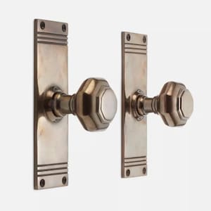 May include: A pair of antique door handles. Each handle has a rectangular backplate with horizontal grooves and an octagonal knob. The handles are made of a metallic material with a tarnished finish.