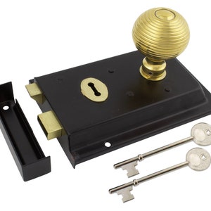 May include: A black door latch with a brass keyhole and two keys. The latch has a decorative brass knob. The strike plate is separate. This hardware is designed for doors.