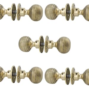 May include: Six brass door knobs with a ribbed, spherical design. Each knob is connected to a circular backplate. The knobs are displayed against a white backdrop, highlighting their vintage appeal. Suitable for home renovation and decorative purposes. Each knob measures approximately 6 cm in diameter.