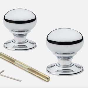 May include: Two polished chrome door knobs with a round, dome-shaped top and a circular base. A long threaded bolt and an Allen key are included. The knobs have a reflective surface, designed for interior doors.