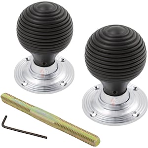 May include: A pair of black, ribbed door knobs with silver-coloured circular bases. A threaded rod and an Allen key are included. The knobs have a classic, rounded design, suitable for interior doors. The hardware is new and ready for installation.