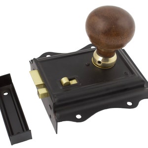May include: Black antique door lock with a wooden knob and brass detailing. The lock is rectangular with decorative edges and includes a separate black strike plate. A classic piece of hardware.