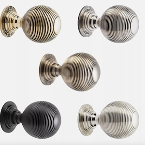 May include: A selection of decorative door knobs in different metallic finishes. The knobs feature a ribbed, spherical design and are displayed in gold, silver, black, and brushed nickel. Each knob has a circular base for mounting.
