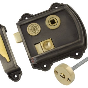 May include: A cast iron rim lock with brass detailing. The lock has a rectangular body with decorative elements, a brass bolt, and a separate strike plate. Includes a brass keyhole cover and a metal key.
