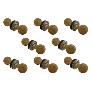 May include: Seven wooden door knobs with a ribbed, spherical design. Each knob is attached to a circular, antique-style metal base. The knobs are a light brown colour, and the metal bases have a dark, aged finish.