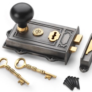 May include: A cast iron door latch set with a black knob, brass accents, and two ornate keys. The set includes a latch, strike plate, and mounting screws. The hardware has a vintage, antique aesthetic.