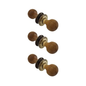 May include: Three wooden door knobs with a ribbed design. Each knob has a dark brown base, a brass-coloured ring, and a light brown, spherical handle. The knobs are arranged diagonally against a white background.