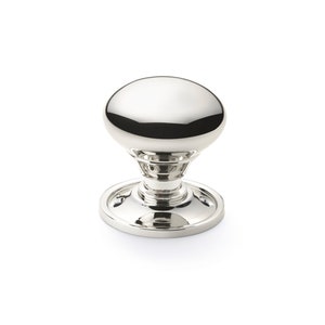 May include: A shiny, silver cabinet knob with a rounded top and a circular base. The knob has a reflective surface, and the design is simple and elegant. The hardware is likely for furniture or cabinetry.