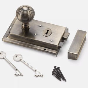 May include: Antique brass door latch set with a round knob, keyhole, and matching strike plate. Includes two keys and mounting screws. The hardware has a vintage aesthetic.