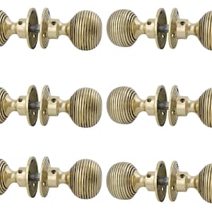 May include: Six antique brass door knobs. Each knob features a ribbed, spherical design, with matching backplates and connecting hardware. The knobs are arranged in two rows of three against a white background.