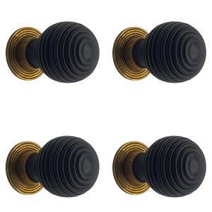 May include: Four black door knobs with a ribbed, spherical design. Each knob is mounted on a round, gold-coloured base. The knobs are arranged in a square formation against a white background.