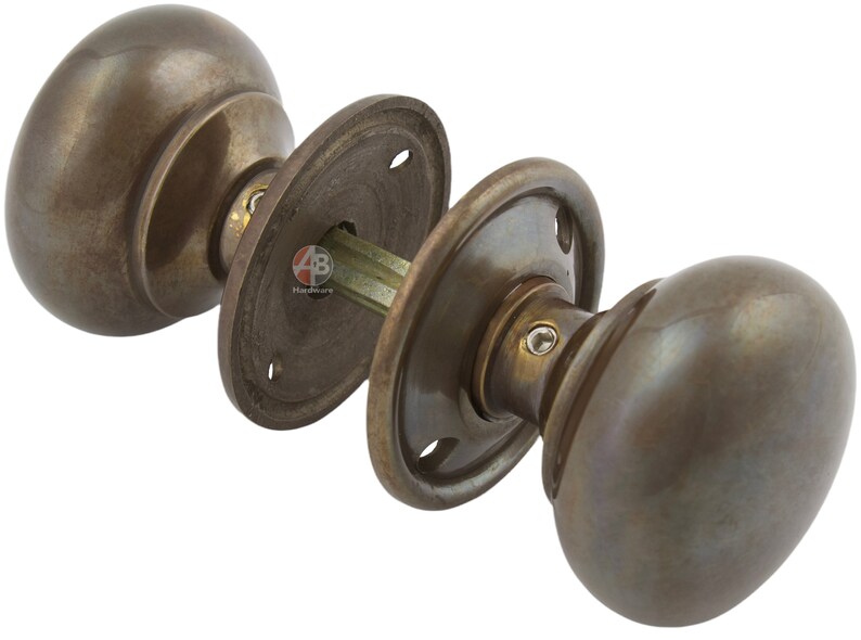 Peut inclure: Ensemble de poign&eacute;es de porte en bronze antique, comprenant deux boutons ovales et des plaques arri&egrave;re circulaires. La quincaillerie pr&eacute;sente un design classique avec une finition patin&eacute;e, adapt&eacute;e aux portes int&eacute;rieures. L'ensemble comprend tous les composants n&eacute;cessaires.