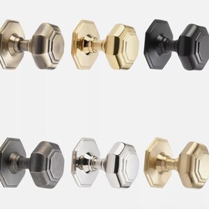May include: A selection of octagonal door knobs in finishes such as brass, black, and silver. The knobs have a classic design, suitable for interior doors. The hardware is displayed against a white background.