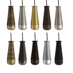 May include: Ten light pull cords in a range of metallic finishes, such as brass, silver, and bronze. Each pull has a ribbed, conical shape with a rounded base and a black cord. The pulls are displayed against a white backdrop, showcasing their varied colours.