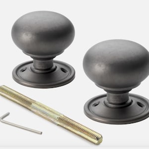 May include: Two grey metal door knobs with a rounded design and matching base. A long threaded bolt and an Allen key are included. Hardware for home improvement.