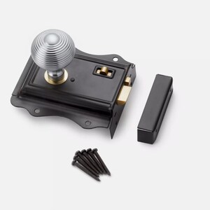 May include: A black door latch with a silver, ridged doorknob. The latch has a rectangular shape with a brass-coloured bolt and a matching strike plate. A set of black screws and a black receiver are also included.