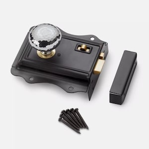 May include: A black door latch set with a decorative, faceted glass knob and brass accents. The set includes a matching strike plate and a small pile of black screws. Suitable for interior doors. The measurements are in centimetres.
