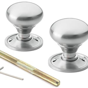 May include: Two brushed steel door knobs with a rounded shape. The knobs are shown with a threaded rod and an Allen key. The door knobs have a classic design, suitable for various interior styles.