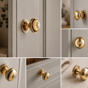 May include: A collection of gold-coloured cabinet knobs with a circular design, shown on light grey cabinet doors and drawers. The knobs have a classic, elegant appearance, suitable for kitchen or bathroom cabinetry. The knobs are made of metal.