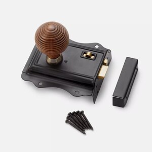 May include: A black door latch with a wooden knob and brass detailing. The latch includes a separate black strike plate and a small pile of black screws. The knob is light brown and has a circular design.