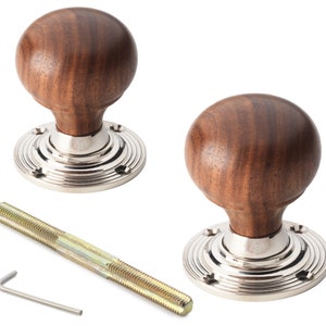 May include: Two wooden door knobs with a polished silver base and a threaded rod. The knobs are a dark brown colour and have a round shape. The base has a circular design with a small number 48 engraved on it.