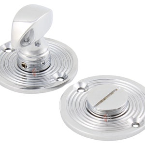 May include: A polished chrome door handle set, comprising a curved lever and a circular base with concentric grooves. The set includes a separate circular plate with a slotted screw. The handle is a classic design.