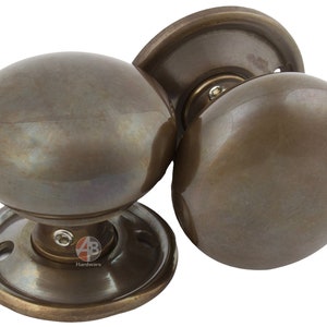 Peut inclure: Boutons de porte en bronze avec un design sph&eacute;rique. Les boutons ont une esth&eacute;tique classique et vintage, avec une plaque de base circulaire et une finition lisse et polie. Quincaillerie de porte.