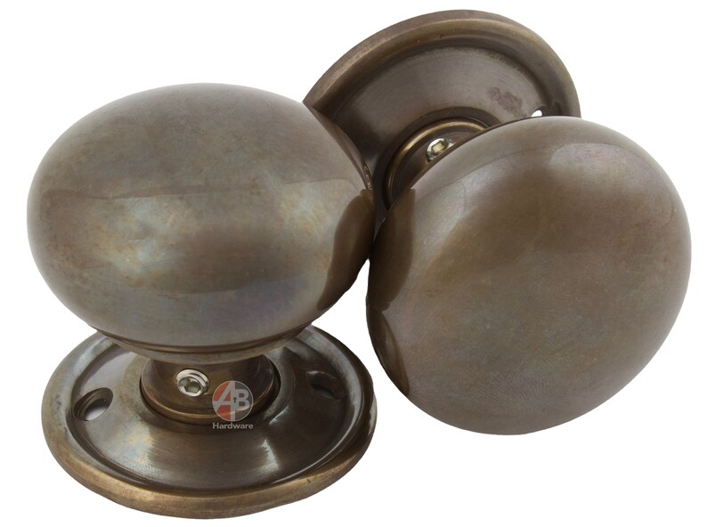 Peut inclure: Boutons de porte en bronze avec un design sph&eacute;rique. Les boutons ont une esth&eacute;tique classique et vintage, avec une plaque de base circulaire et une finition lisse et polie. Quincaillerie de porte.